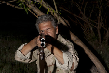 Man in camouflage clothes ready to hunt with hunting rifle