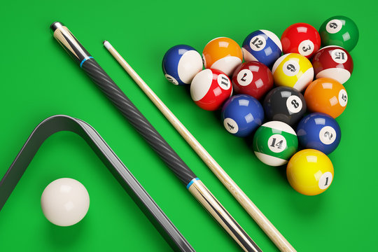 Group of billiard colored balls, cues and triangle on green tabl