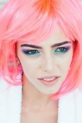woman with bright makeup and orange pink hair