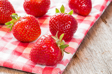 Strawberries on checkered napkin.