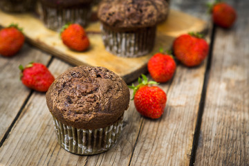 Chocolate muffins on the rustic wooden table. Shallow depth of field.