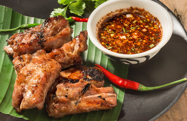 pork rip grill with garnish on wooden table.