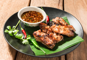 pork rip grill with garnish on wooden table.