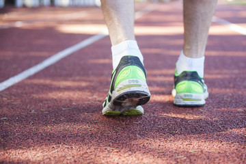 Fototapeta na wymiar Feet in running shoes on stadium running path