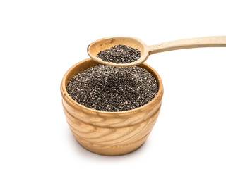 Chia seeds in a wooden bowl with a wooden spoon over  it on a white background