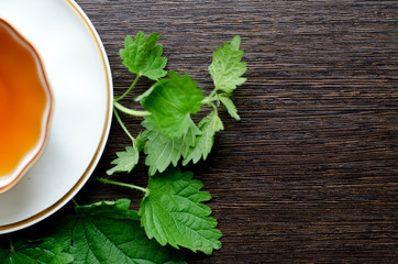 natural herbal haemostatic - organic yarrow tea

in a white porcelain сup with fresh green leaves on a dark wooden table, shot at an angle of 90 degrees, for labels, packages, menus, etc
