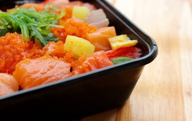 Colorful small sushi in the black box on the wooden background