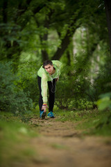 Pretty young woman exercising in the park and listening to a music.
