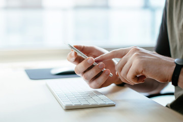 Young graphic designer working at home, Project Manager uses the phone to work in the office, Workplace in the early morning, Shallow DOF.