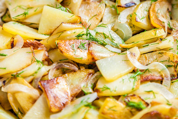 Delicious fried potatoes with onion and fresh dill closeup. Selective focus, very shallow depth of field