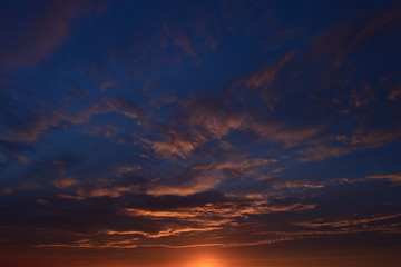 Sunset in the blue cloudy sky on a summer evening