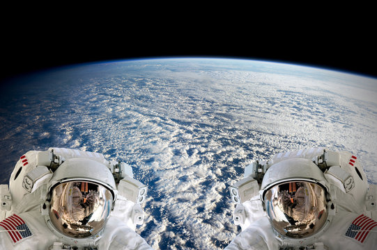 High resolution planet Earth two astronauts spaceman helmet suit floating people outer space walk. Elements of this image furnished by NASA.