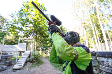 Cool extreme sportsman shooting from paintball marker