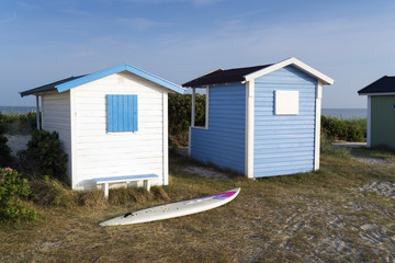 Fototapeta na wymiar Strandhütten und Surfbrett am Strand von Skanör, Südschweden