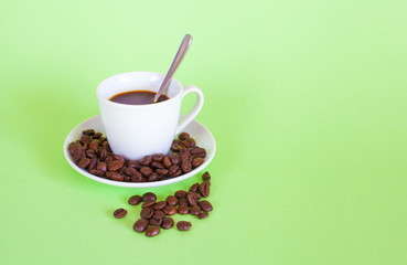 Espresso and coffee beans on pastel green background
