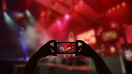 Take photo crowd in front of concert stage blurred