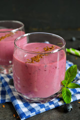 berry smoothie with blueberries, oats and flax seeds on a black