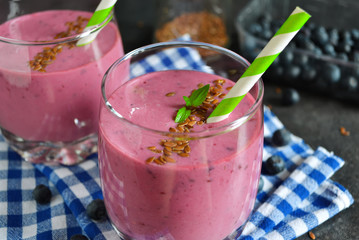 berry smoothie with blueberries, oats and flax seeds on a black