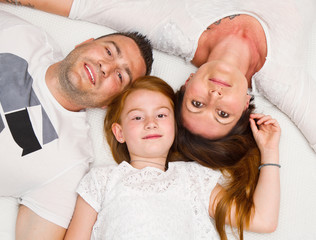 
    Smiling family having fun lying on the bed 