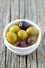 olives in a bowl on wooden surface