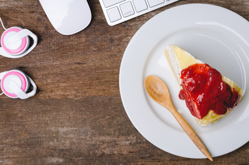 Top view of old wooden working table with crape cake, computer k