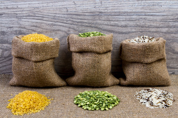 Fototapeta na wymiar Set groats, peas, rice, millet, peas in sacks, burlap on wooden background
