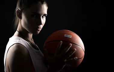 Gordijnen portrait of a beautiful and sexy girl with a basketball in studio © kulichok