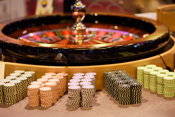 Close up of wooden roulette and chips in casino, selective focus
