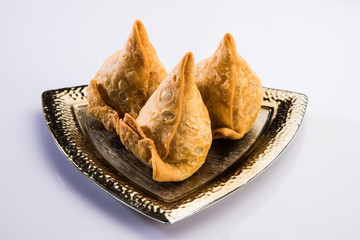 Veg Samosa - is a crispy and spicy Indian triangle shape snack which has crisp outer layer of maida & filling of mashed potato, peas and spices. Served with fried green chilly, onion & chutney/ketchup