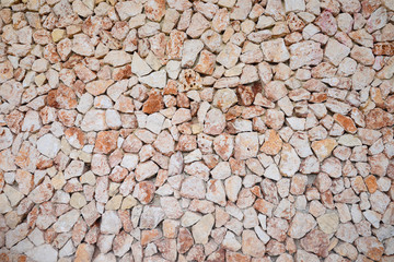 Large wall of brown and pink colored stones texture