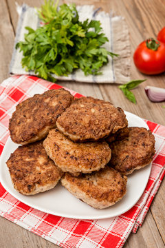  Fried pork burgers with tomatoes on the wooden rustic table. grilled pork cutlets.