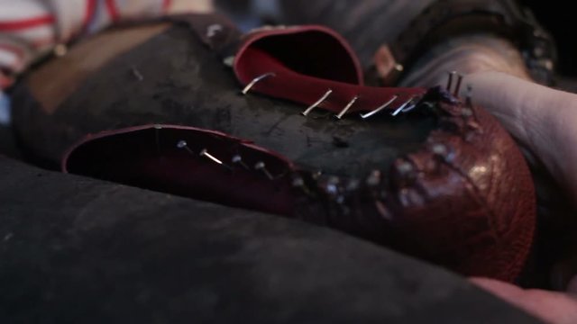 Shoemaker sews shoes. Hammering shoe leather