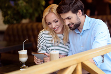 Cheerful loving couple having rest in cafeteria