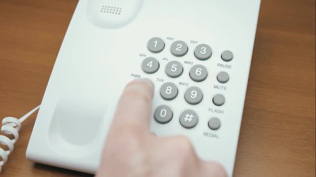 Hand picks up the white (black) phone, dials a number and hangs up