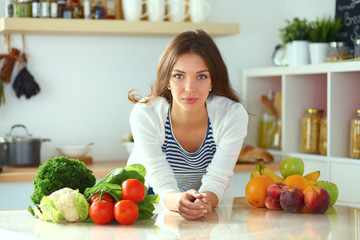 Young woman standing near desk in the kitchen