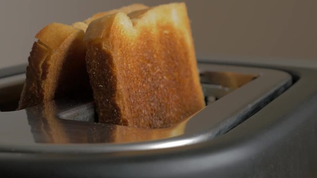 Roasted bread popping up from toaster machine 4K 2160p UHD footage - Toasting bread in toaster close-up 4K 3840X2160 UHD video 