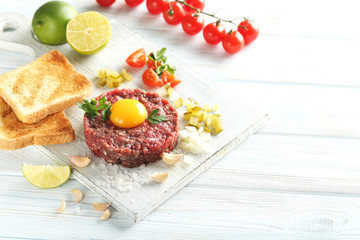 Beef tartare with egg yolk on a blue wooden table
