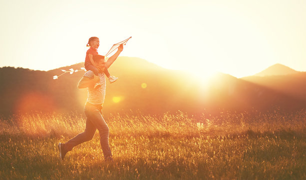 Happy Family Father And Child Run On Meadow With A Kite In Summe