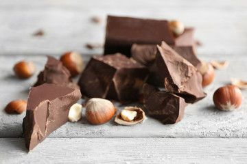 Chocolate pieces with nuts on wooden background