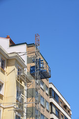Fototapeta na wymiar grúa en la fachada de un edificio