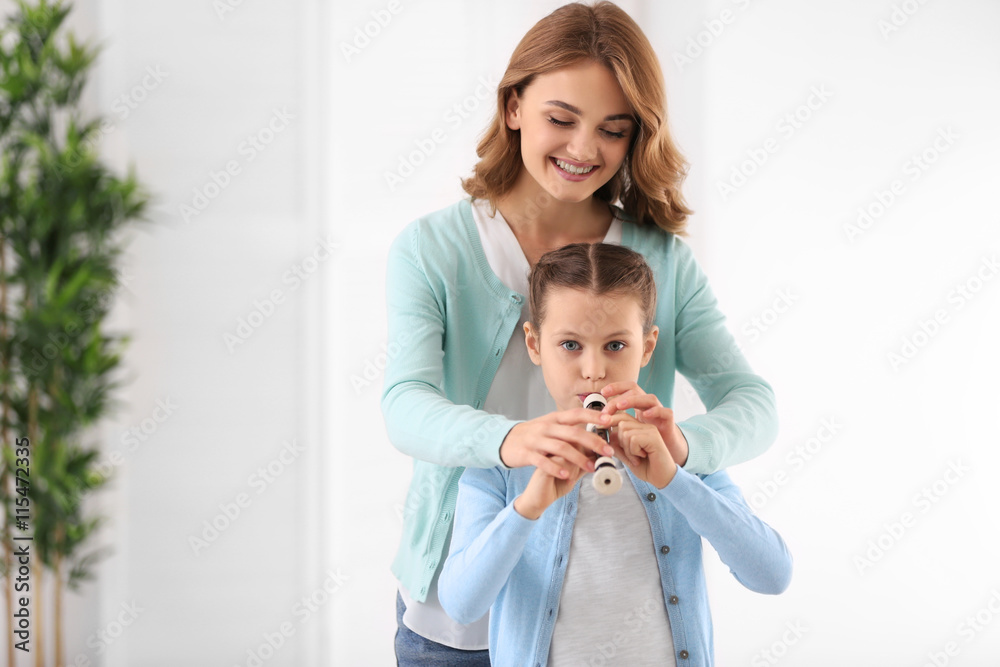 Poster Small girl learning play flute with teacher