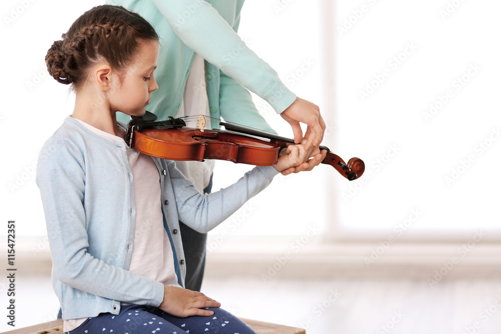 Poster small girl learning play violin with teacher