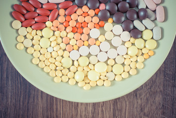 Vintage photo, Colorful medical pills, tablets and capsules on plate, health care concept