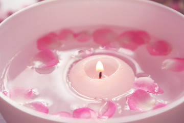 Obraz na płótnie Canvas Petals on bowl with candle, closeup