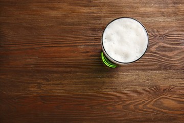 Glass of green beer on wooden background