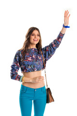 Obraz premium Young girl waves her hand. Woman in crop top smiling. Meeting old friends. Happy model in casual outfit.