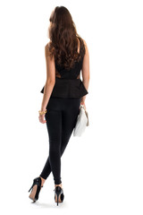 Girl wearing black outfit. Short blouse and skinny pants. Gold bracelets and expensive shoes. Model in glamour clothing.