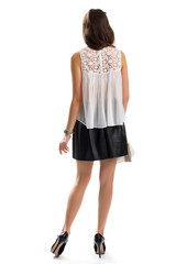 Woman wears short skirt. Back view of white blouse. Trendy apparel from boutique. Small wrist watch.