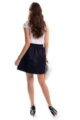 Woman in skirt and heels. Back view of dark skirt. Casual outfit with suede shoes. Look stylish this spring.