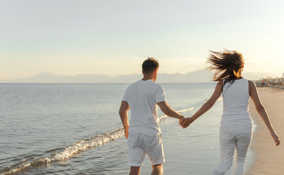 Young Couple Playing About Beach